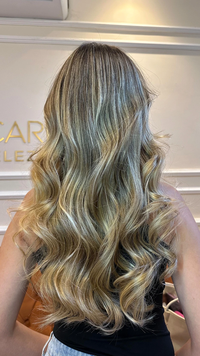 Resultado de cabelo longo com mechas claras e ondas, visto de costas.
