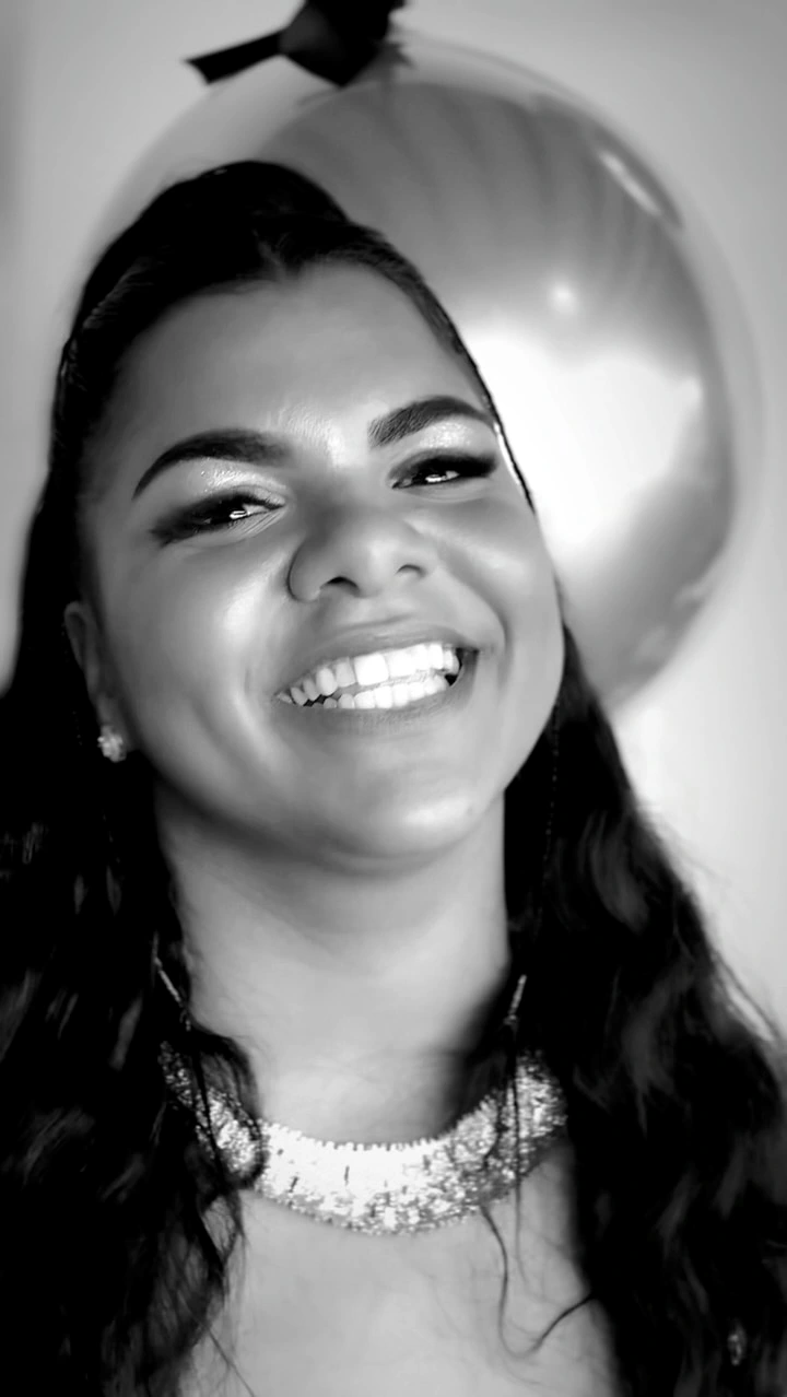 Retrato em preto e branco de mulher sorrindo com cabelo longo e ondas.
